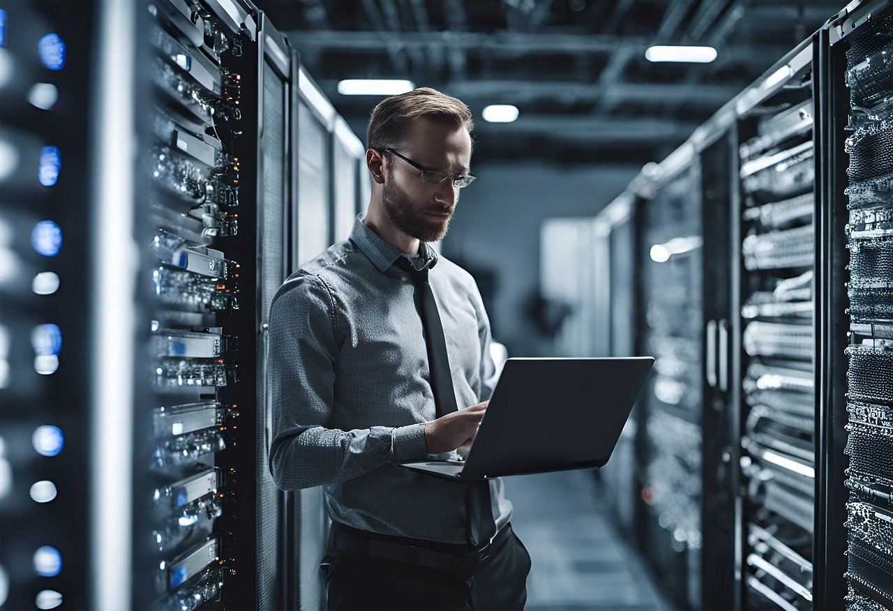IT specialist with a laptop standing in a server room